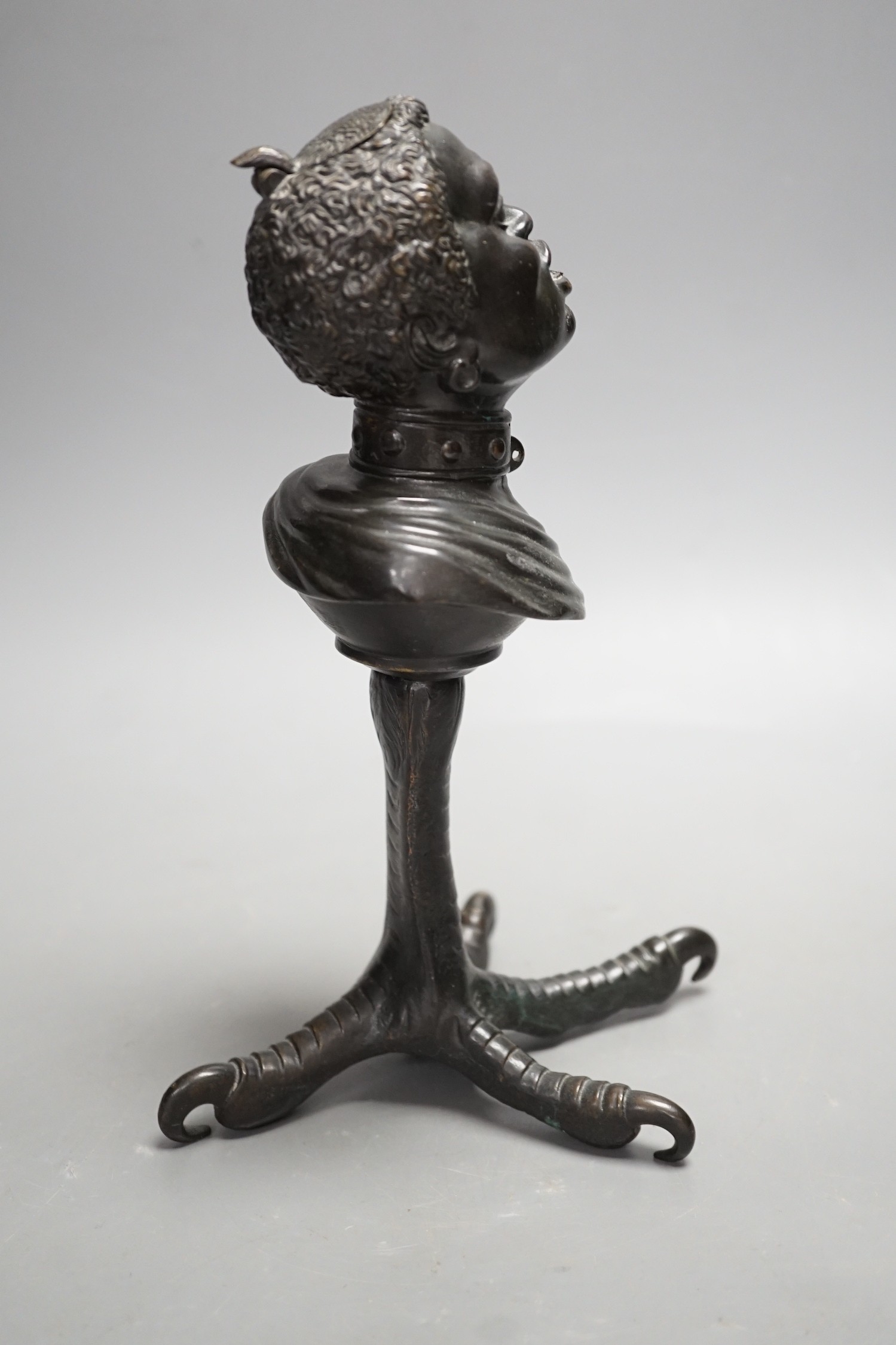 A bronze slave portrait bust on claw stand. 23cm high